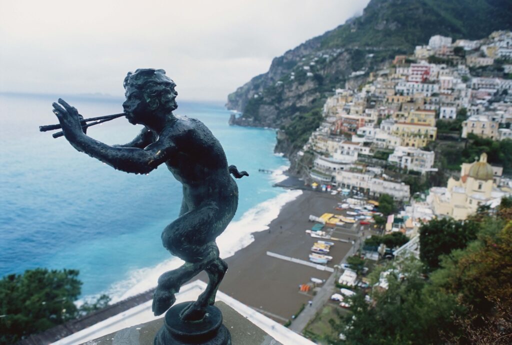bronze-of-pan-above-town-with-ocean-528274542-5908f19a5f9b58647093f7ab
