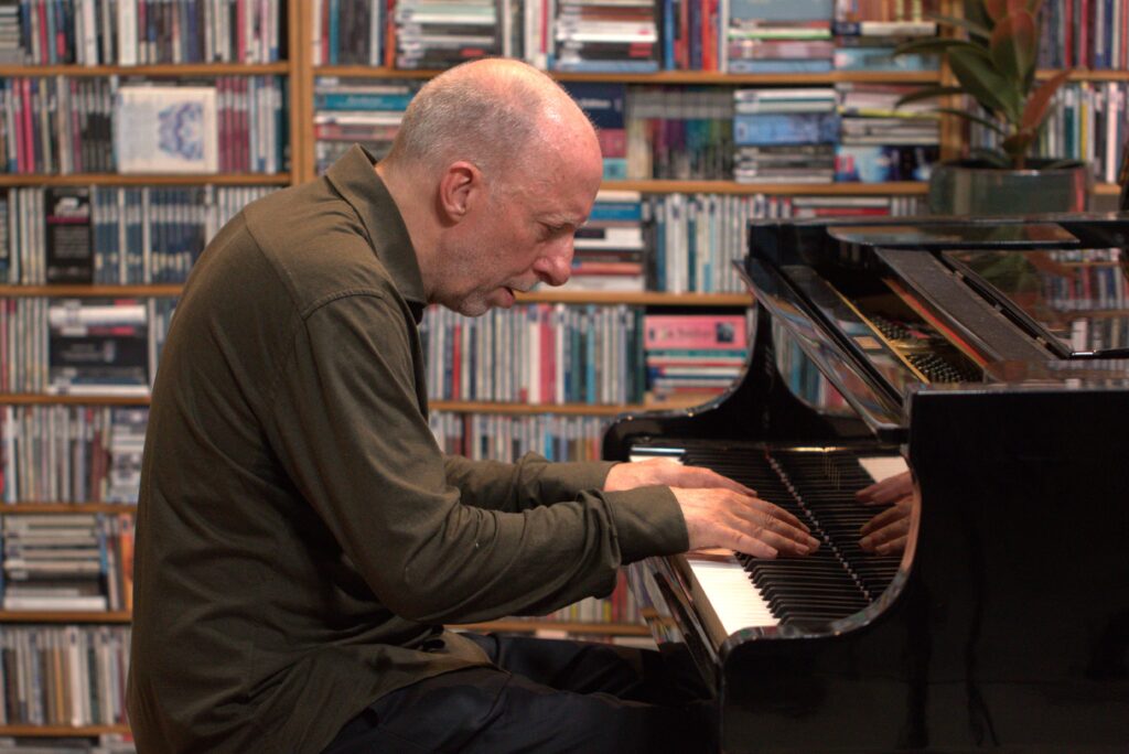 man speelt piano aan vleugel